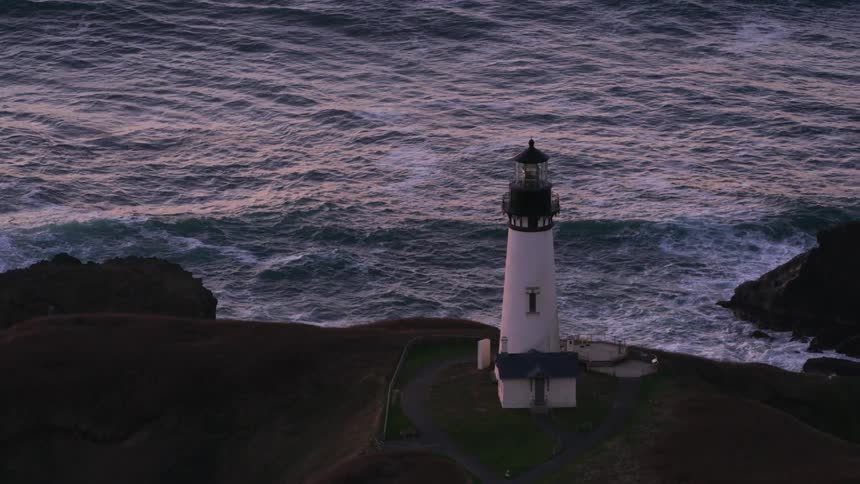 A lighthouse sits on a cliff overlooking the ocean