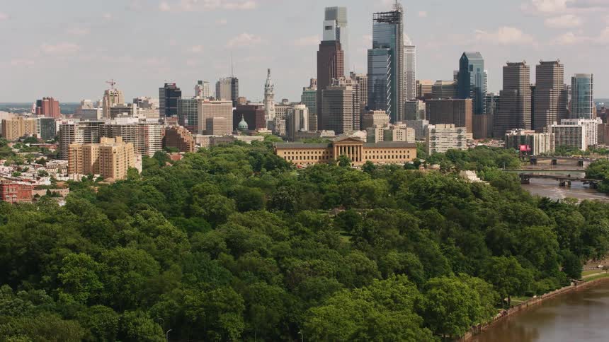 Aerial view of bridges over a river flowing near a park through a city at daytime