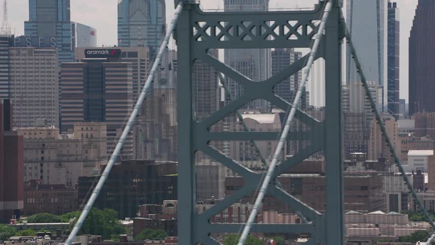 An aerial shot of a dowtown metropolis with a bridge and many skyscrapers