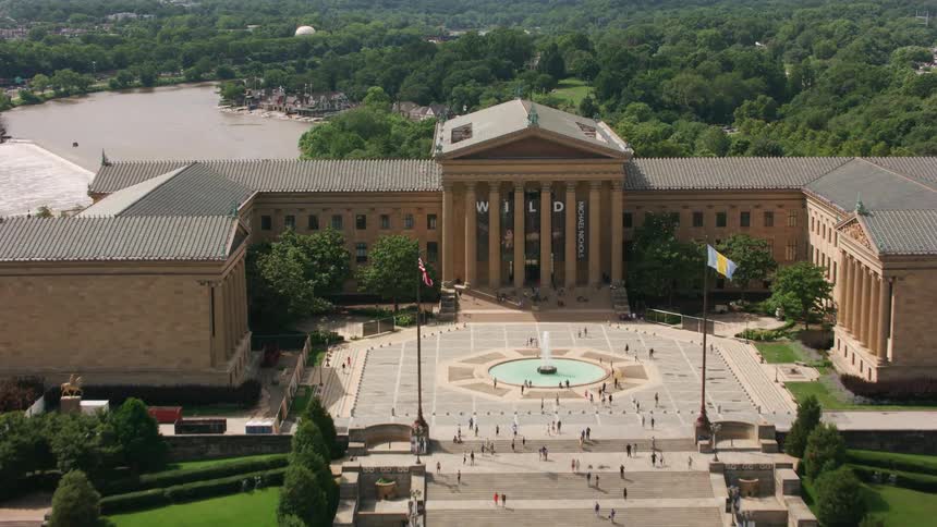 An aerial shot of a large monument building and trees behind it