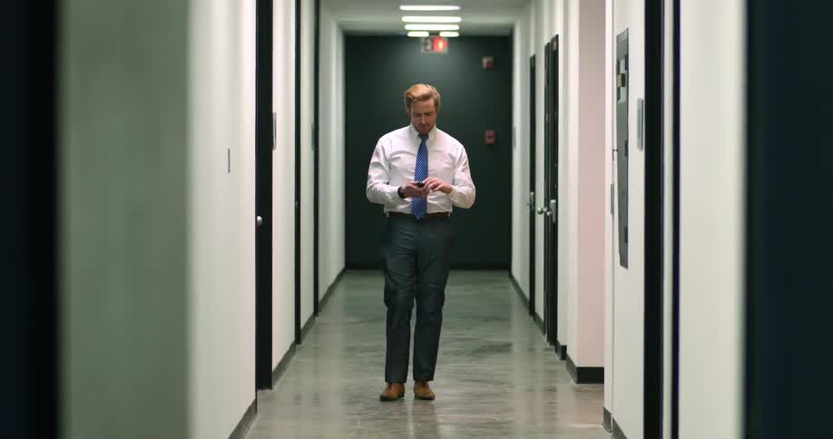 A man walks down an empty hallway