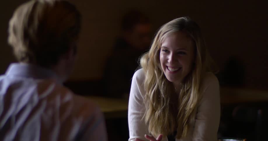 A man and a woman sitting at a table laughing and chatting