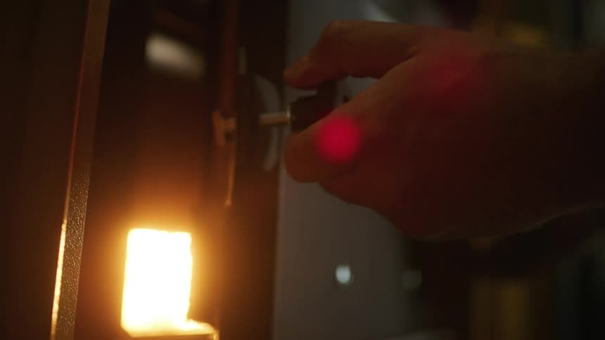 A man opens the door to a kiln to reveal a fire