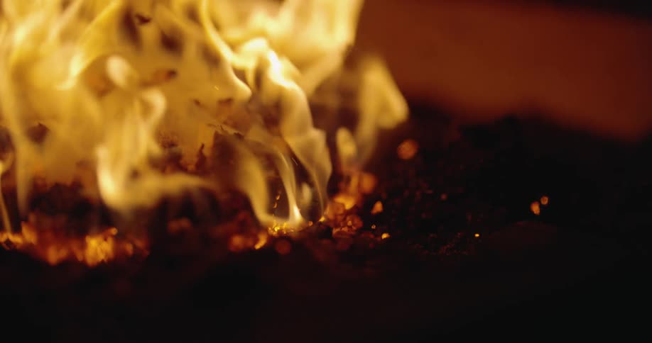 Flames grow taller from lumps of charcoal