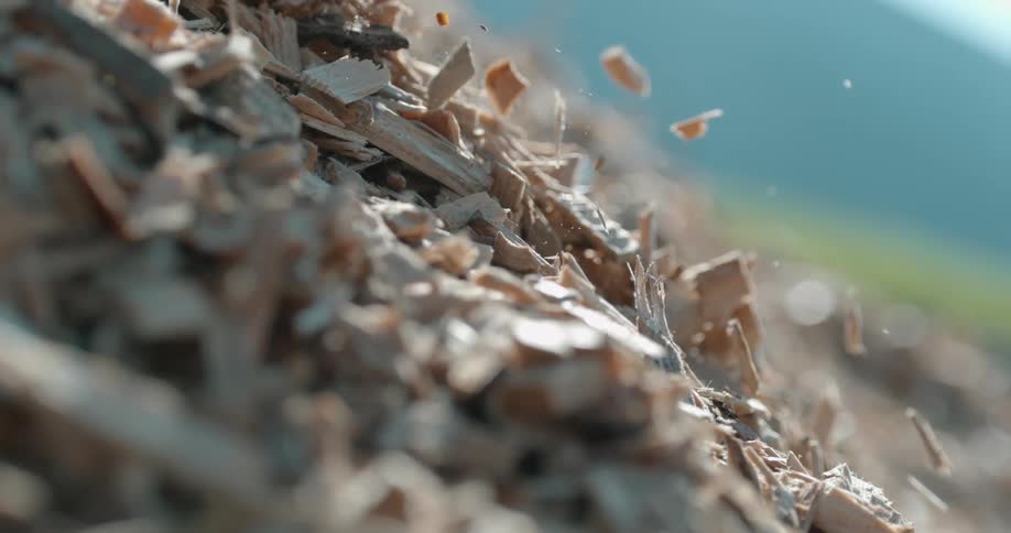 Wood chips fall from a pile of mulch