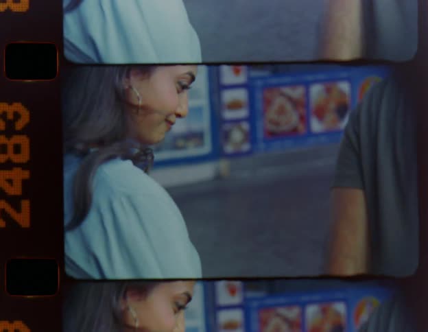 A man and a woman are standing together on a downtown street as she looks at him