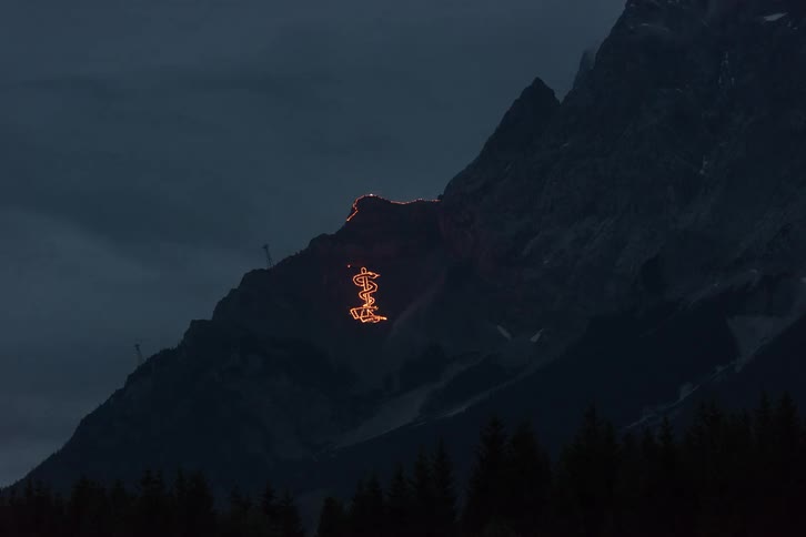 Lava glows bright orange on the side of a volcano