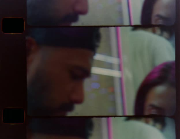 A man and woman chat while eating next to a window in a casual restaurant