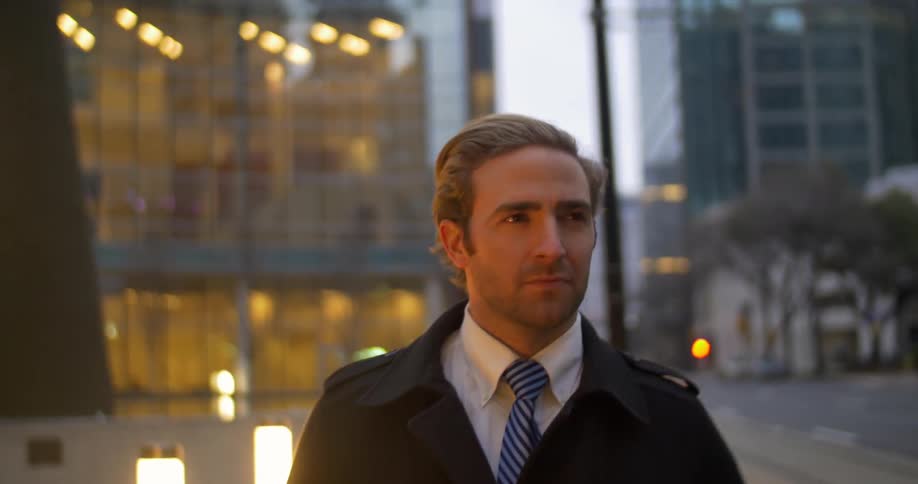 Well-dressed man walking down a city street