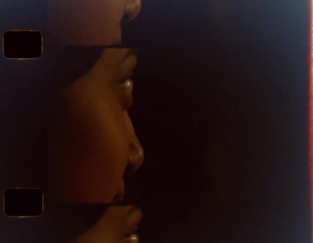 Woman smiles and bobs her head while conversing with man in dim lighting