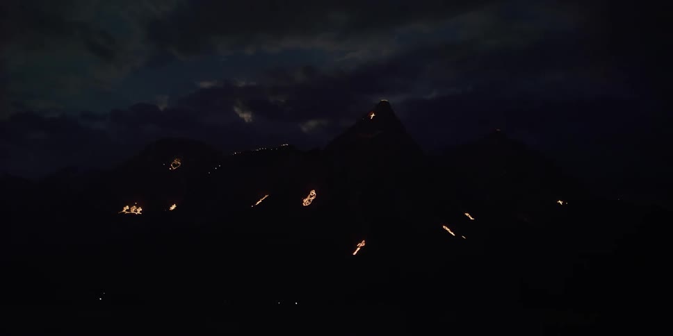 Glowing lights shine on the side of a mountain