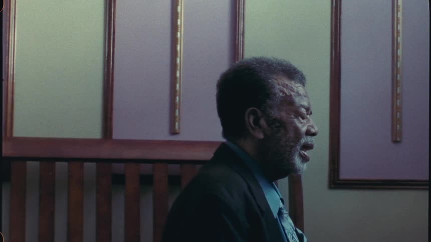 An old man is inside a church engaged in prayer with his eyes closed he utters words of devotion expressing his spiritual connection and dedication