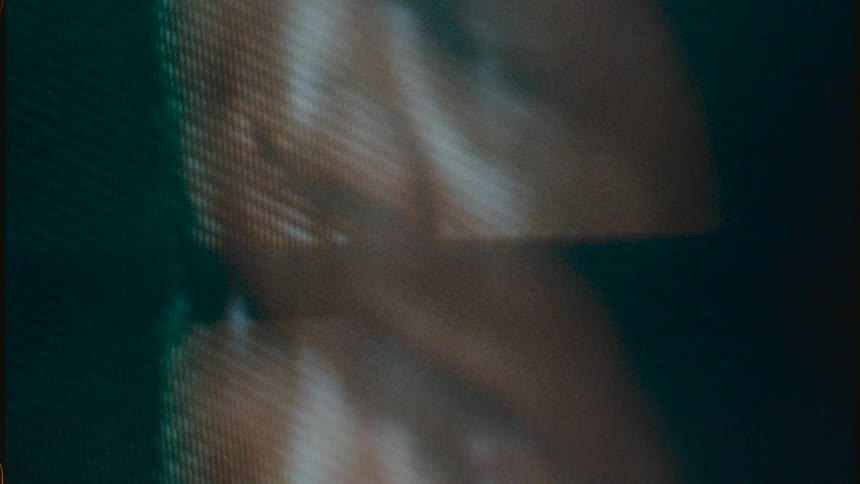 A close up of a pixelated television screen flashing back and forth with an image of a man on it