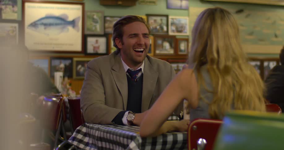 A man and woman at a table in a restaurant chatting and laughing