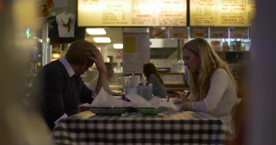 Two people are sitting together in a restaurant