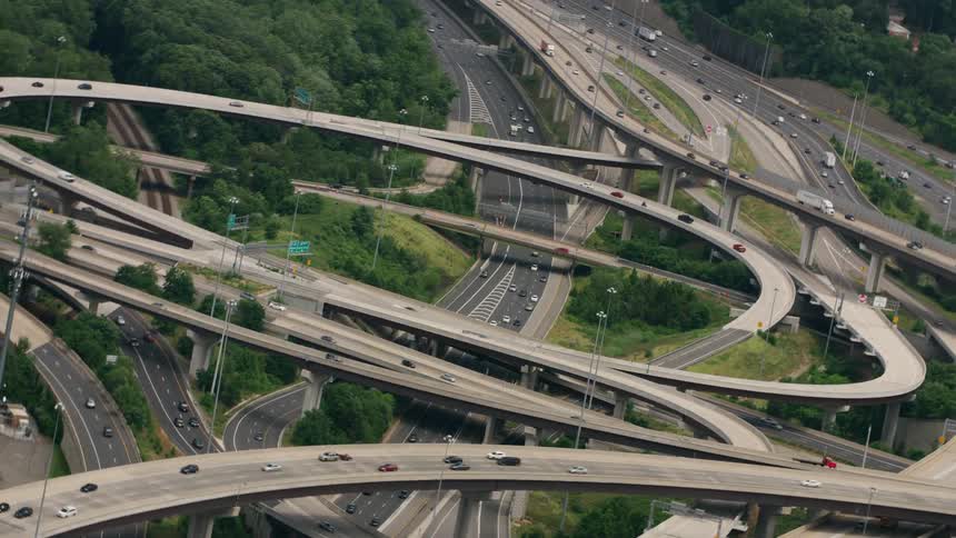 Traffic on a super highway junction moves around curves and over and under the roads of a complex highway system