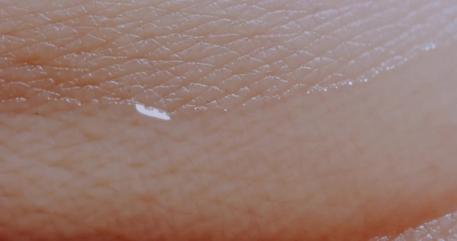 A drop of water running across human skin