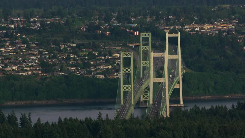 Twin highway bridges connecting a margin covered mostly by a city and another mostly forest