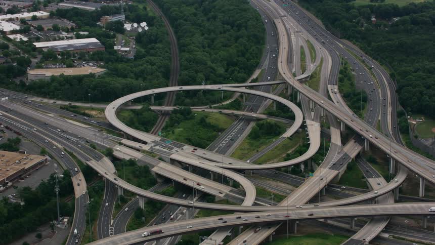 Vehicles drive down an elaborate highway system in the suburbs