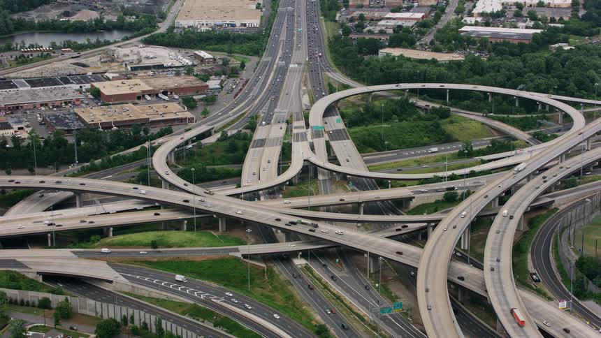 Vehicles drive down a connected freeway in a city