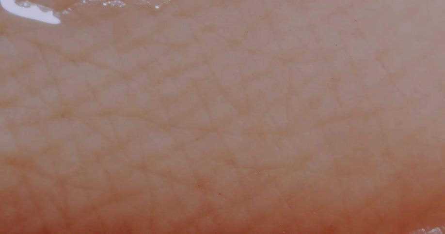 A droplet of water rushing across human skin
