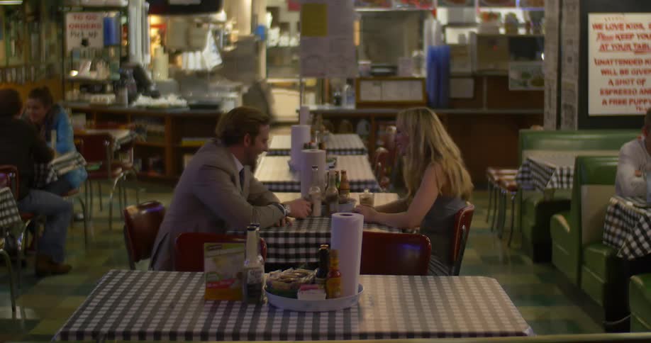 A man and woman sitting at a table in a restaurant talking