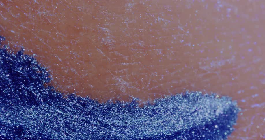 A blue liquid made of tiny particles oozing over human skin