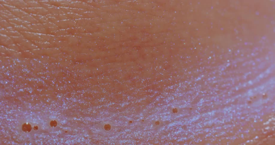 A shiny liquid running over human skin
