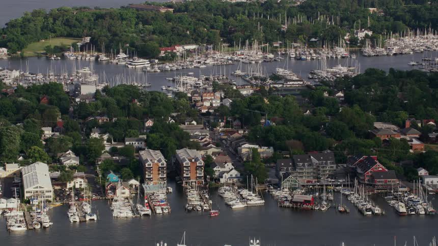 Boats are parked outside homes and in a marina along a river