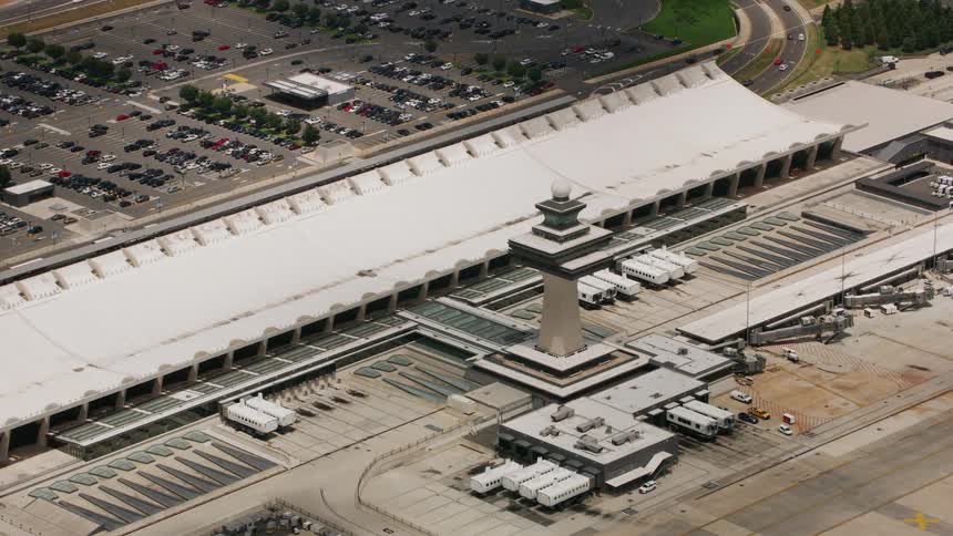 The airport radio control tower is near the buses