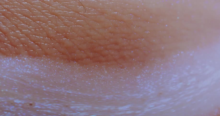 Soap foam sparkles as it flows across textured skin
