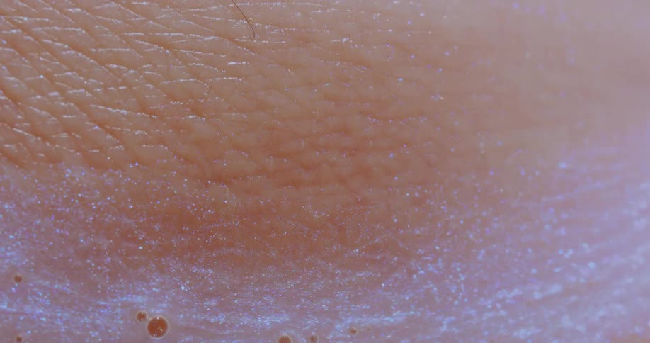 A close up of a persons skin with glitter slowly moving over it