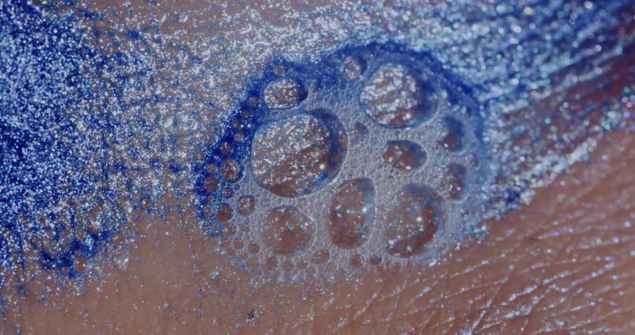 Liquid glitter soap bubbles on human skin