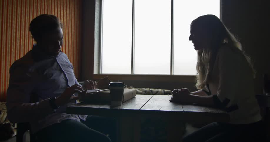 A man and a woman sitting and chatting at a table