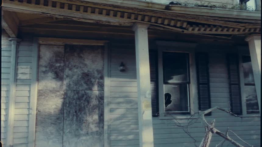 A warning signs sits outside a condemned home
