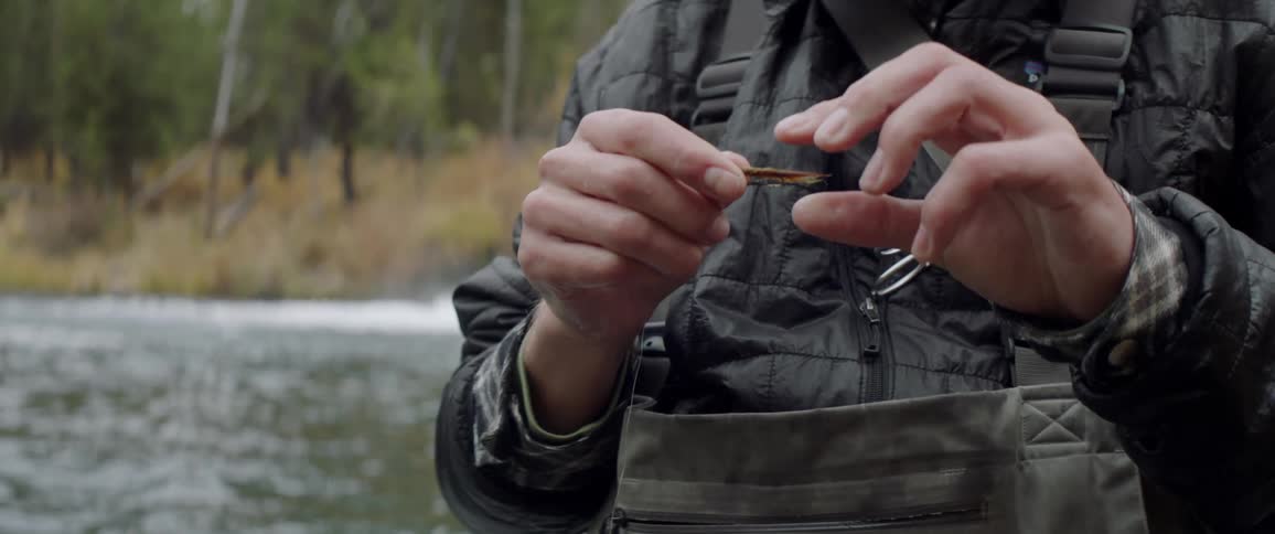 A fisherman adjusts a piece of bait