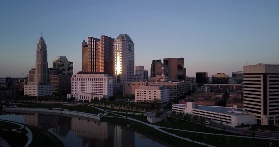 The tall buildings ahead are reflecting the setting sun