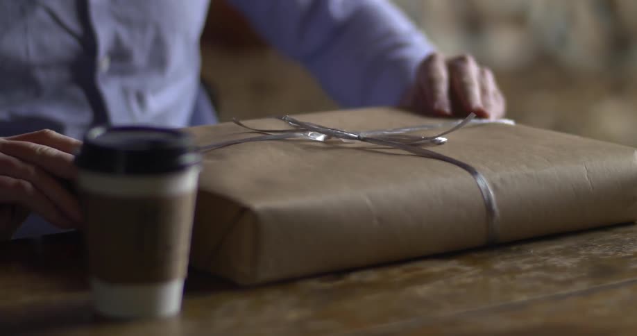 A man receiving and unwrapping a gift