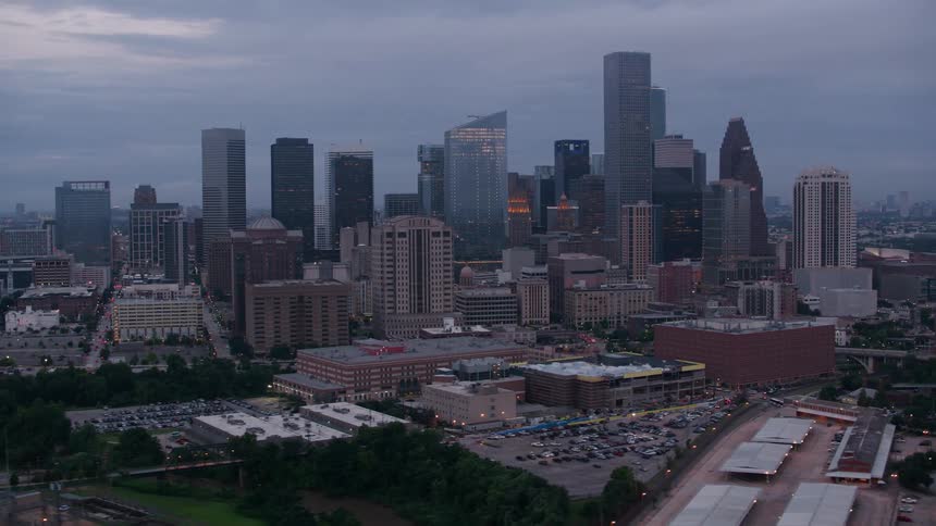 Cars drive down city streets past high rise office buildings