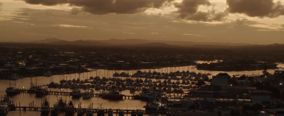 A marina at dusk with tens of boats docked