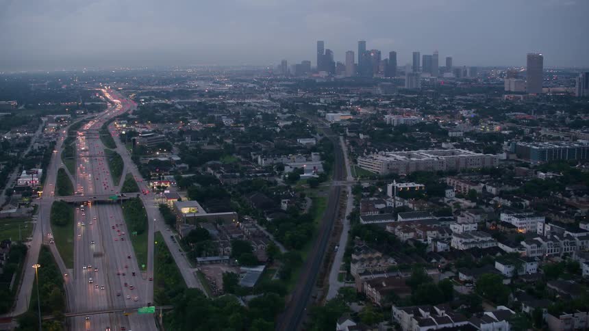 Aerial view of vehicles driving on highways and city skyline