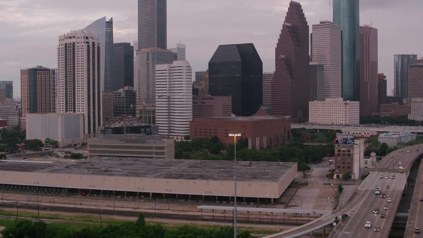 Traffic drives along highways near city downtown dotted with buildings under construction