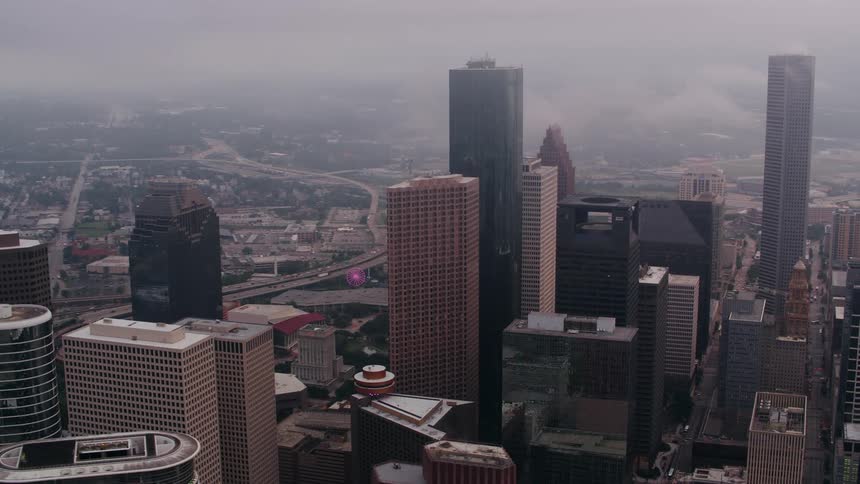Towers and skyscrapers stand tall overlooking the city under a cloudy sky