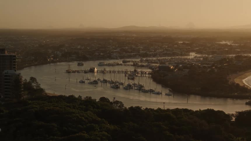 Sun tinted fog covers from waterfront and marina to mountains on the horizon
