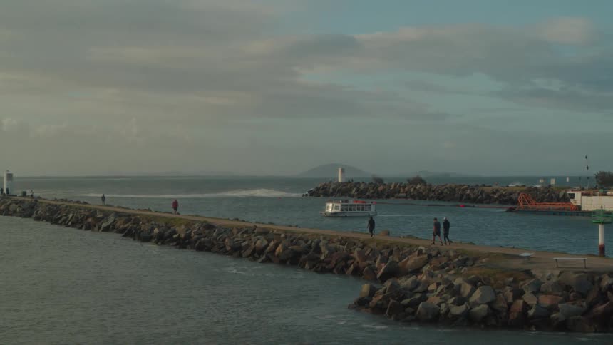 Five people walking up and down a stone pier