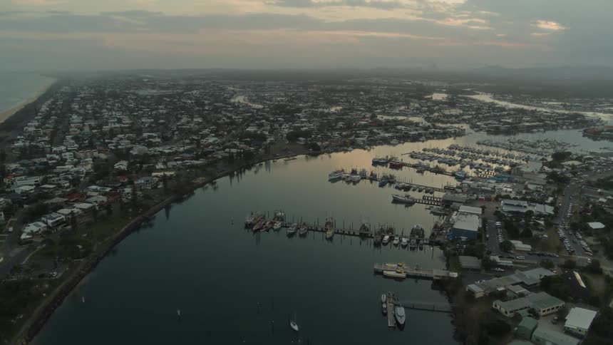 A river dividing a city full of piers with many boats