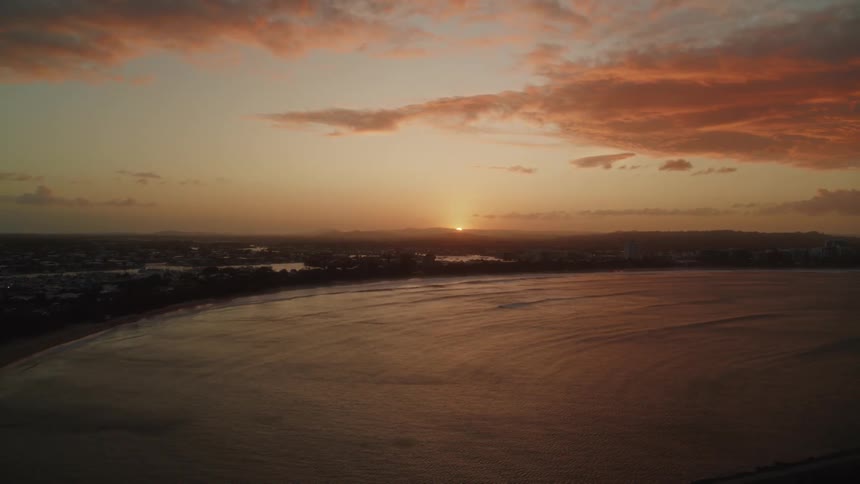 The shore and waterway with the sun rising in the distance