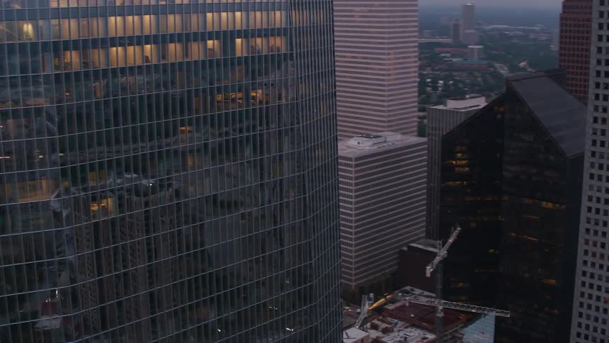 A tower block in a large city dominated by a glass skyscraper