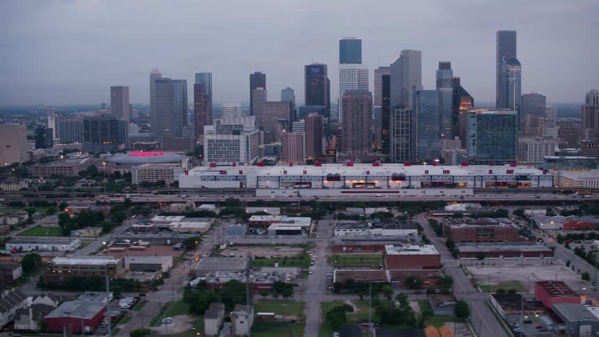 An aerial view of a highway running parallel to a downtown urban area with skyscrapers