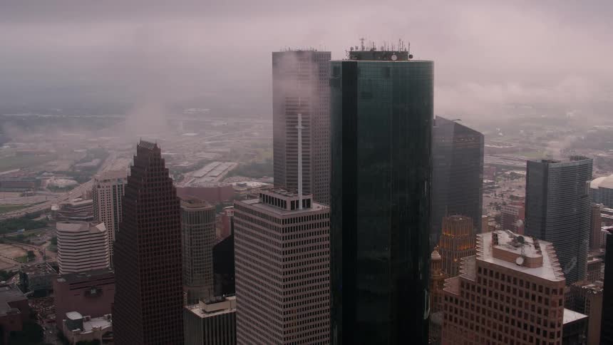 Tall buildings and skyscrapers overlook the city under a cloudy sky